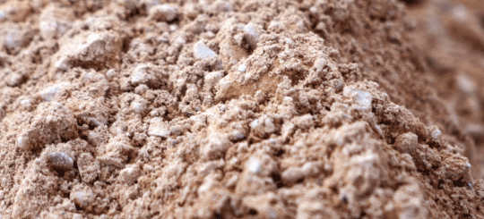 Windrow of dirt and gravel along a residential driveway