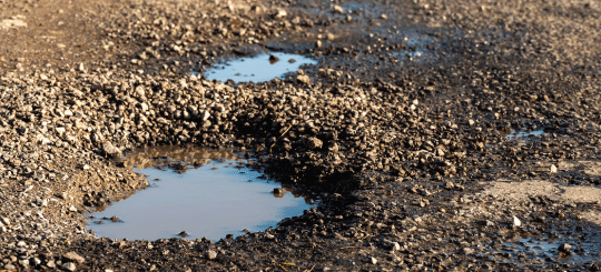 Potholes in an unpaved access road for a renewable energy project