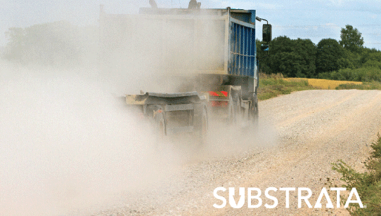 Heavy duty haul truck trailing a massive dust cloud on a renewable energy supplier's road